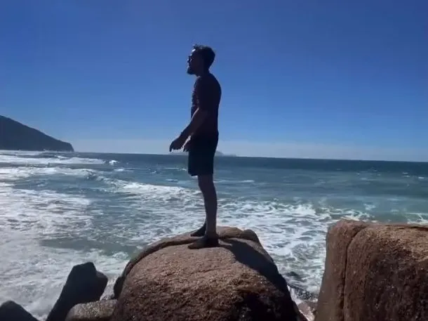 Costão de pedras em Ingleses Norte com uma pessoa olhando o mar