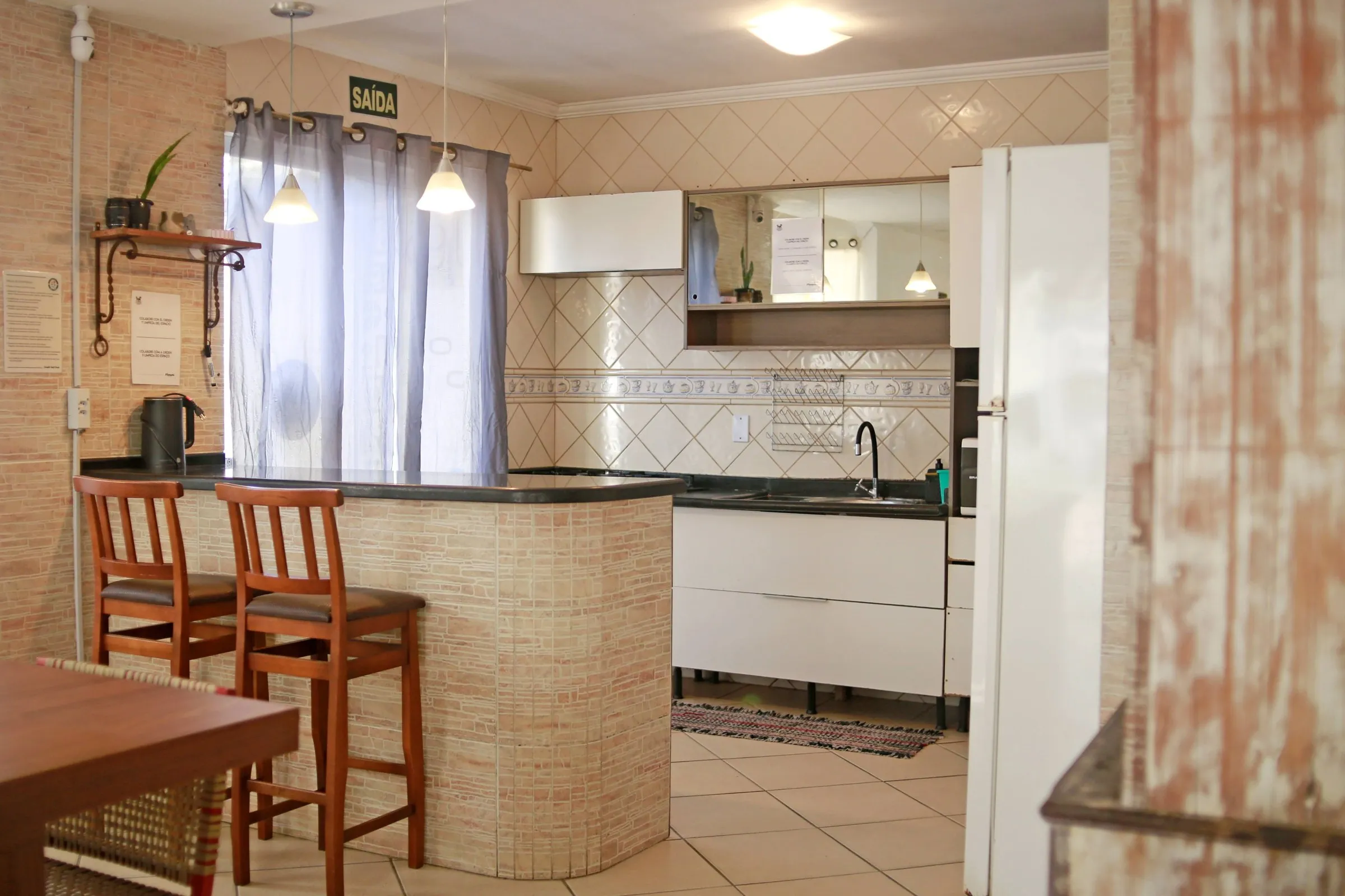 Cozinha compartilhada com bancada e banquetas