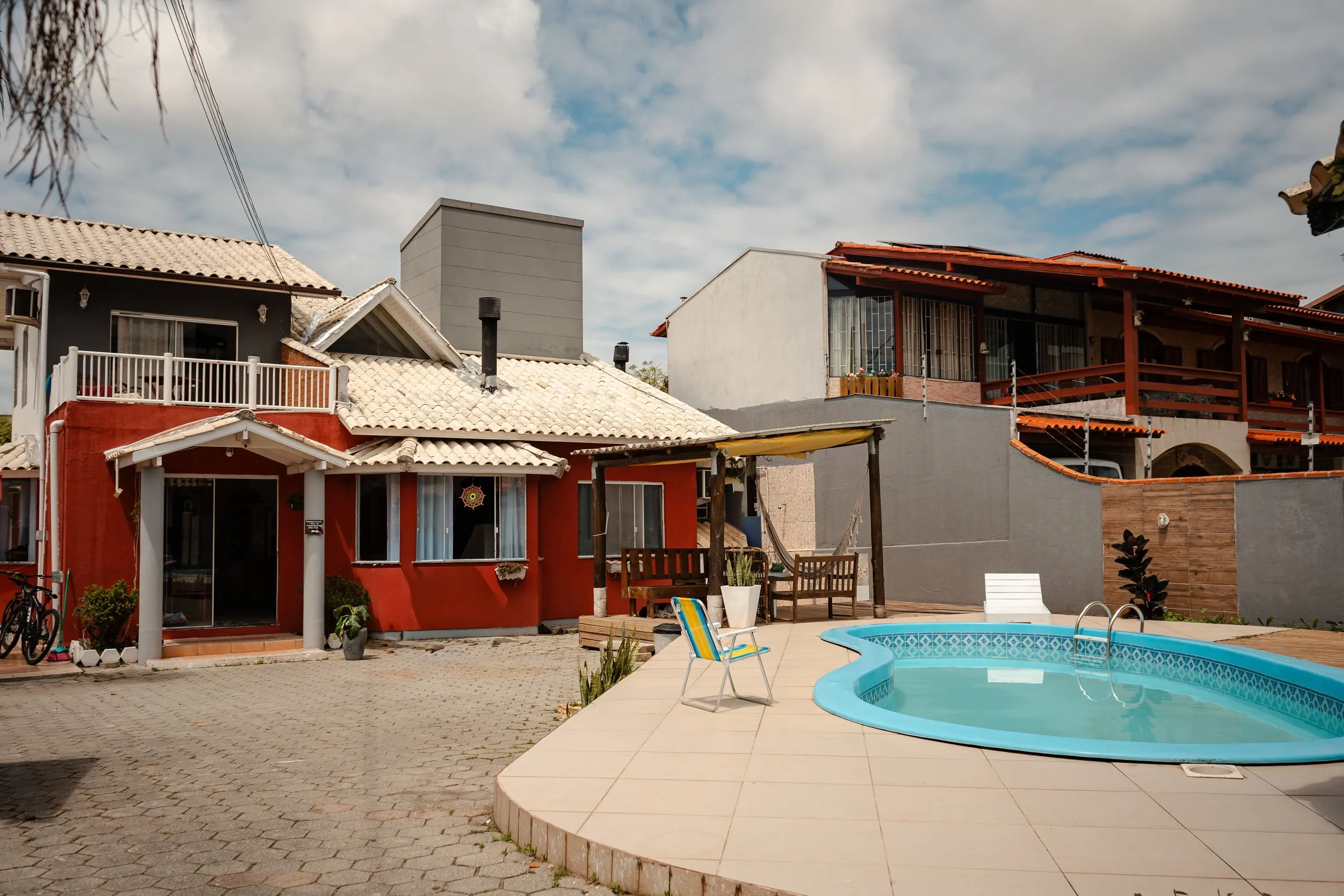 Fachada vermelha da Floriarte com a piscina em primeiro plano