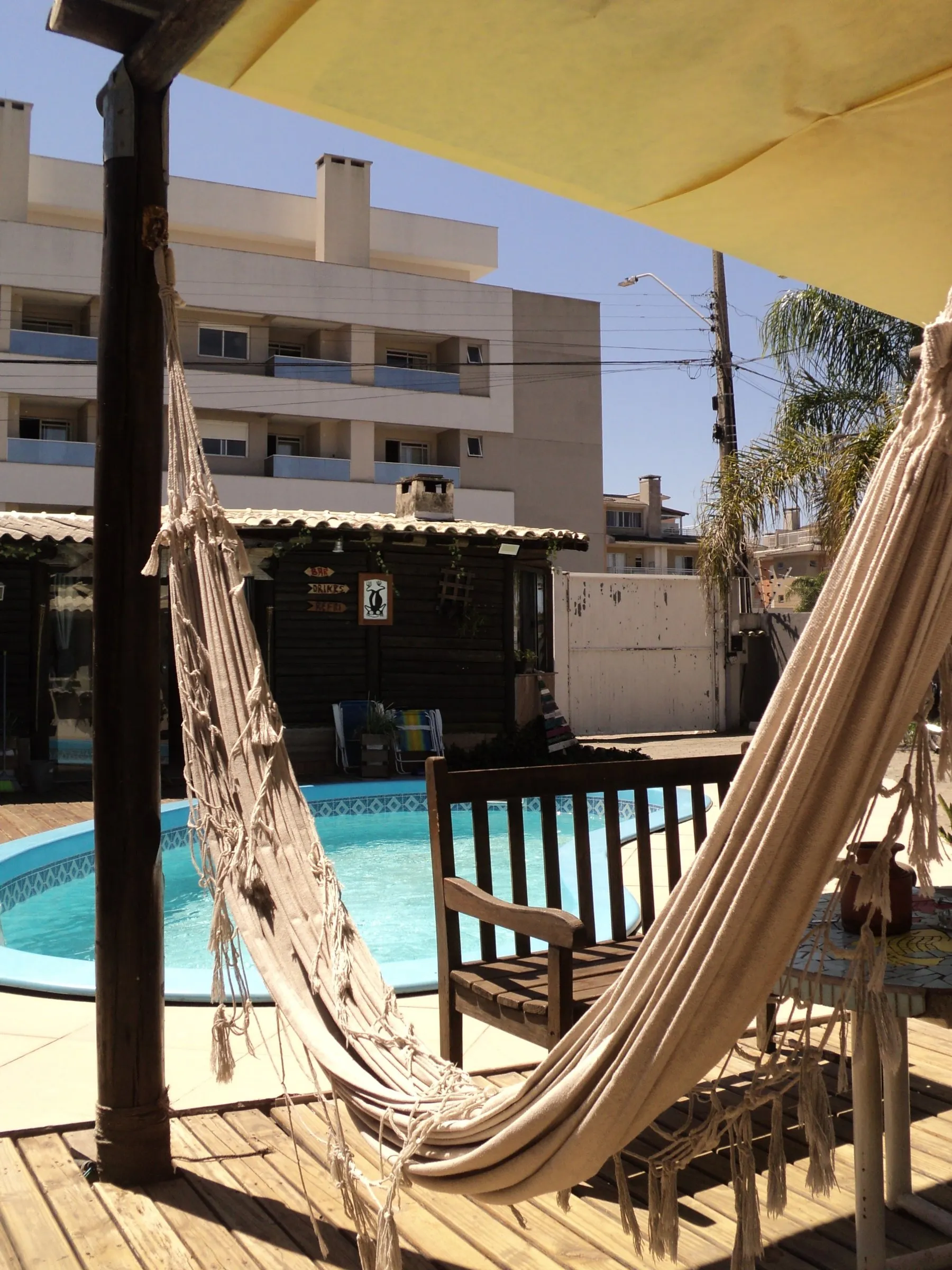 Rede na varanda de madeira ao lado da piscina